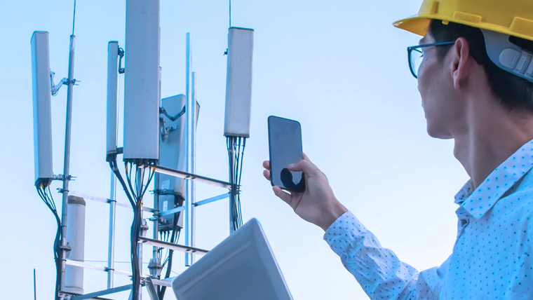 worker using phone on cell tower